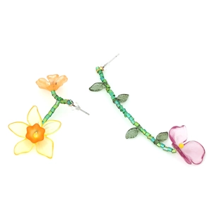 Close-up of asymmetrical handmade beaded flower earrings with resin petals and green stems