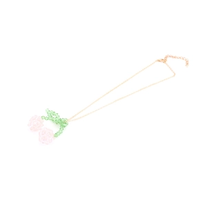Detail of beaded cherry pendant with faceted pink crystals and gold link chain
