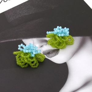 Handmade woven flower earrings with blue crystal beads and green seed bead accents