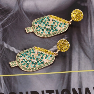 Vintage gold ice cream earrings with colorful rhinestones and pearls on a magazine