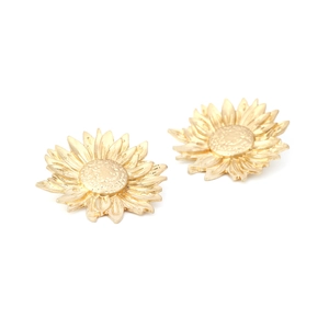 Detailed macro view of gold sunflower earrings with matte textured petals and center