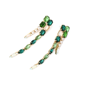Close-up of geometric tassel earrings with emerald green and champagne rhinestones