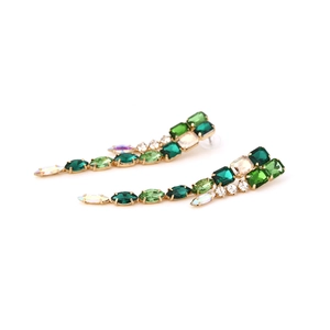 Macro detail of geometric green and iridescent rhinestones on long tassel drop earrings