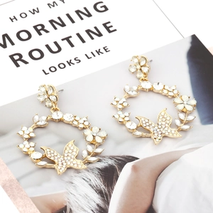 Detailed close-up of crystal butterfly wreath earrings with intricate rhinestone inlay