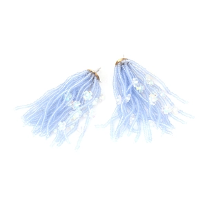 Close-up of light blue beaded tassel earrings with small white floral accents