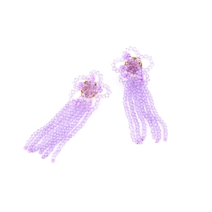 Detail view of purple crystal bead tassel earrings with handmade floral woven design