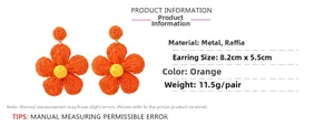 Detail of orange raffia flower earrings showing 8.2cm size and woven texture