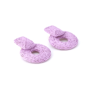Makroaufnahme von handgewebten Lavendel-Raffia-Ohrringen mit geometrischer Strickstruktur