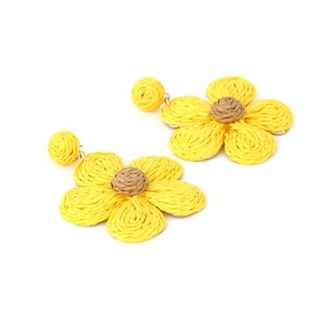 Detailed view of handmade woven raffia flower earrings with yellow petals and brown centers