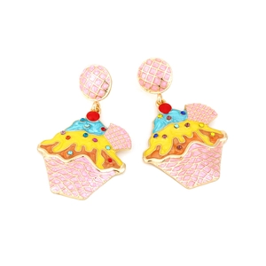 Macro detail of cupcake earrings featuring colorful enamel finish and sparkling rhinestones