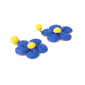 Detail of handmade woven raffia flower earrings in blue and yellow boho style