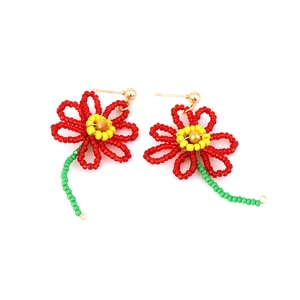 Orecchini a fiore fatti a mano con perline rosse e nucleo giallo su sfondo bianco