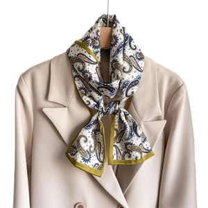 Écharpe élégante en soie à motif paisley sur le revers d'un costume beige chic