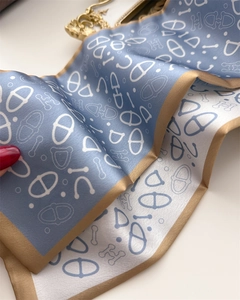 Detailed macro view of the double-layer silk scarf featuring H patterns and horse motifs