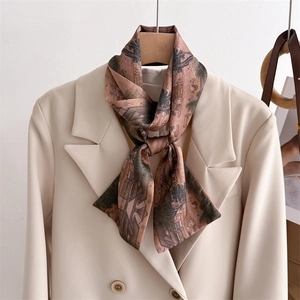 Detail of silk scarf with vintage landscape print styled on a beige blazer collar