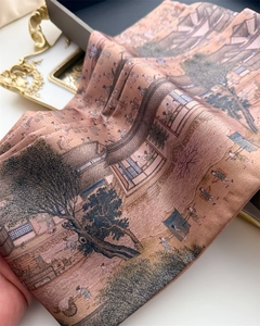 Detail showing the silk-like texture and traditional Chinese print on the elegant scarf