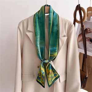 Detailed landscape print silk scarf elegantly knotted on a beige blazer lapel