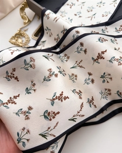 Detailed macro view of the floral print silk scarf featuring a premium satin texture