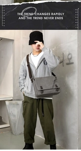 Gray canvas messenger bag on model with adjustable strap in casual workwear style