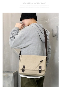 Detail of beige canvas messenger bag with double buckles and brown leather accents