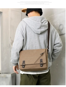 Close-up of brown canvas messenger bag with leather straps and vintage buckles