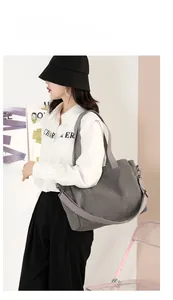 Gray canvas tote bag shown as a shoulder bag on a model for a stylish casual daily look