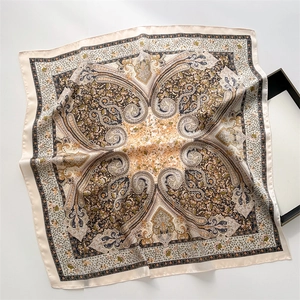 Close-up of vintage paisley print silk square scarf with satin texture and fold detail