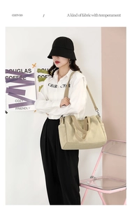 Detail of minimalist beige canvas tote bag with adjustable strap and side pocket