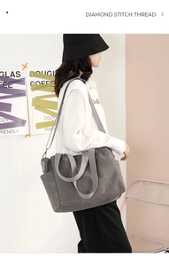 Detail of grey canvas tote bag featuring side pockets and adjustable shoulder strap