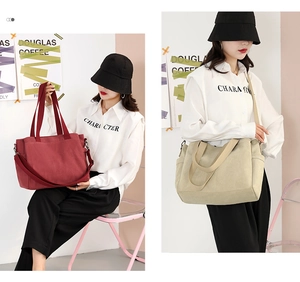 Detail of large canvas tote bag with adjustable strap and side pocket in burgundy and beige