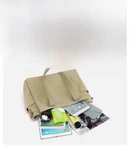 Detail view of khaki canvas tote bag featuring multi-layer compartments for storage
