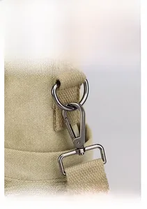 Detail of canvas bag shoulder strap with gun-black metal lobster clasp and D-ring