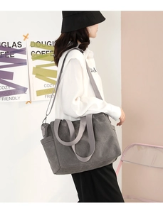 Detailed view of the large dark grey canvas tote bag with side pocket and shoulder strap