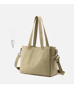 Detail of khaki canvas tote bag showing side pocket and adjustable crossbody strap