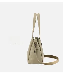 Detail of khaki canvas tote bag showing side pocket, handles and adjustable strap