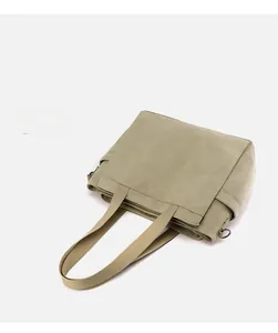 Detail shot of canvas shoulder bag side pocket and metallic strap ring connector