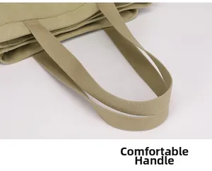 Detail of the reinforced comfortable woven handle on a large khaki canvas tote bag