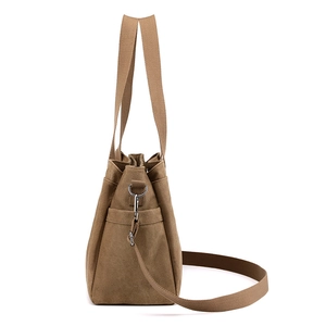 Brown canvas tote bag with top handles and adjustable shoulder strap on white background