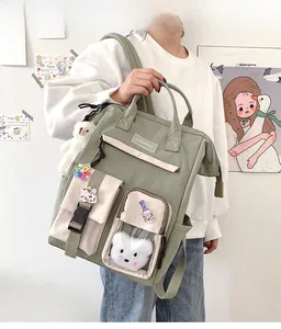 Detail view of sage green backpack with transparent PVC pocket and cute plush accessories