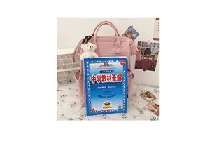 Pink large-capacity backpack shown with an A4 textbook and a cute bear plush keychain