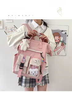 Detailed view of pink school backpack with cute cow patches and a white teddy bear charm