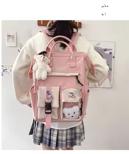 Pink nylon backpack with white bear pendant and cute cow patch shown on model back