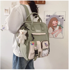 Detail view of large capacity school backpack with multiple pockets and cute bear pendant