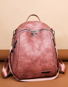 Detalle de mochila de cuero rosa con textura granulada y cremalleras metálicas