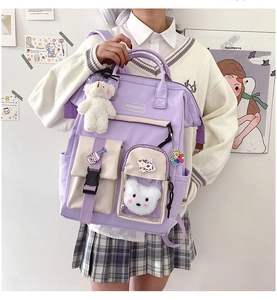 Detail of purple nylon backpack featuring cartoon patches and a plush bear pendant