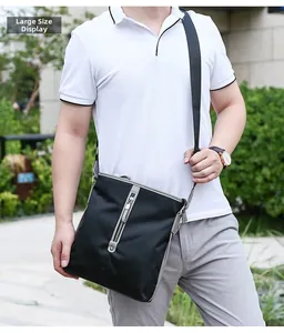 Outdoor shot of a man wearing the large version black oxford nylon crossbody bag