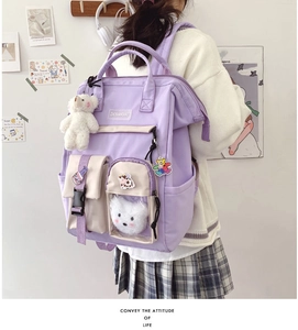 Detail of lavender school backpack featuring plush charms and cute pins in high-school style