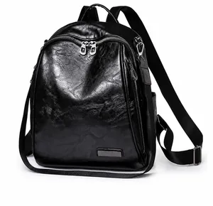 Detalle de mochila negra de cuero sintético con cremallera doble y bolsillos