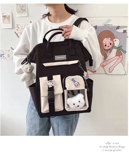 Detail of canvas backpack with transparent pocket and plush bear pendant accessory