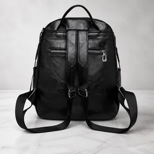 Vista trasera de mochila de cuero negro con bolsillo con cremallera antirrobo y correas
